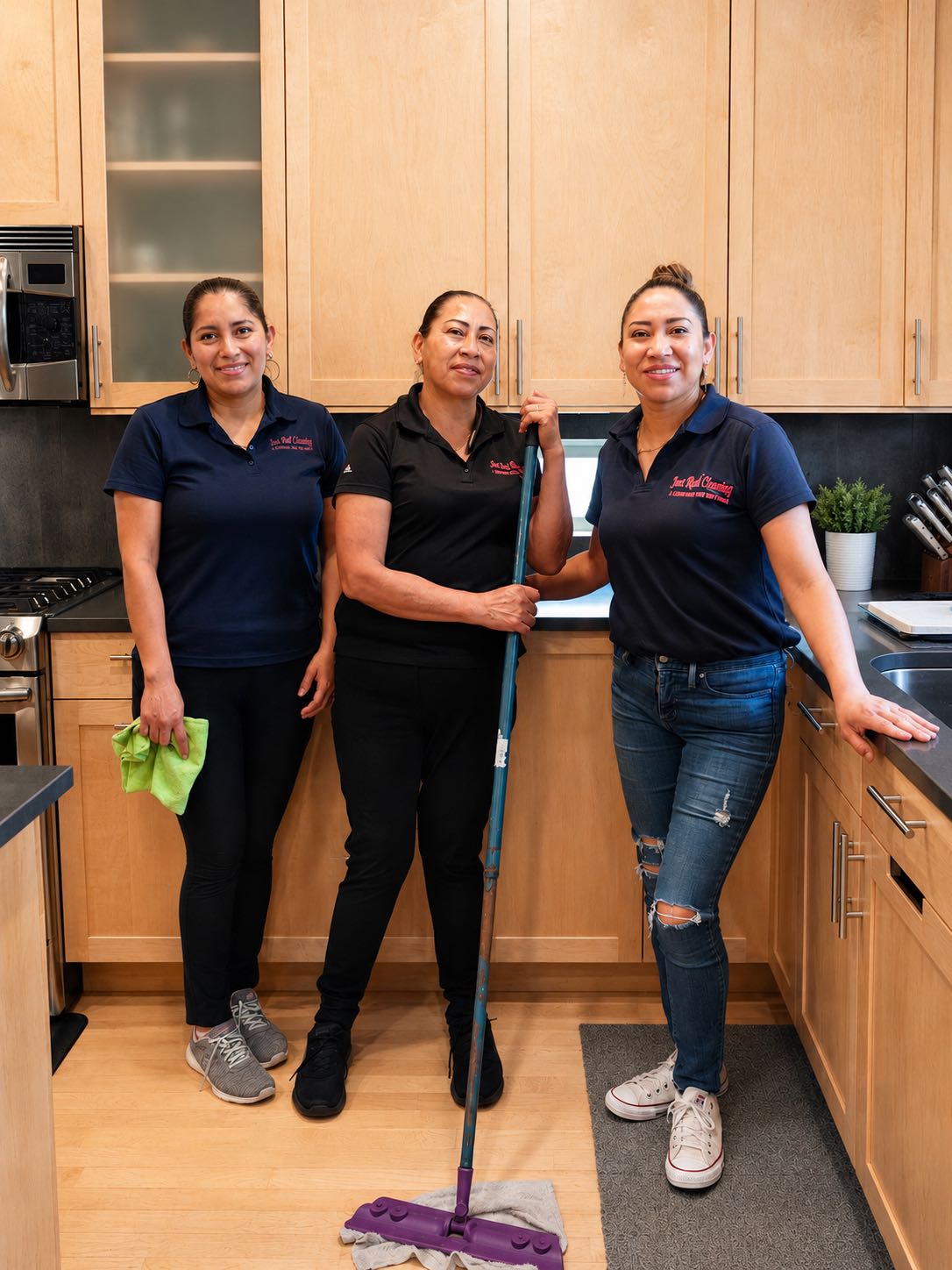 Members of the Just Real Cleaning family team smiling in a freshly cleaned kitchen.