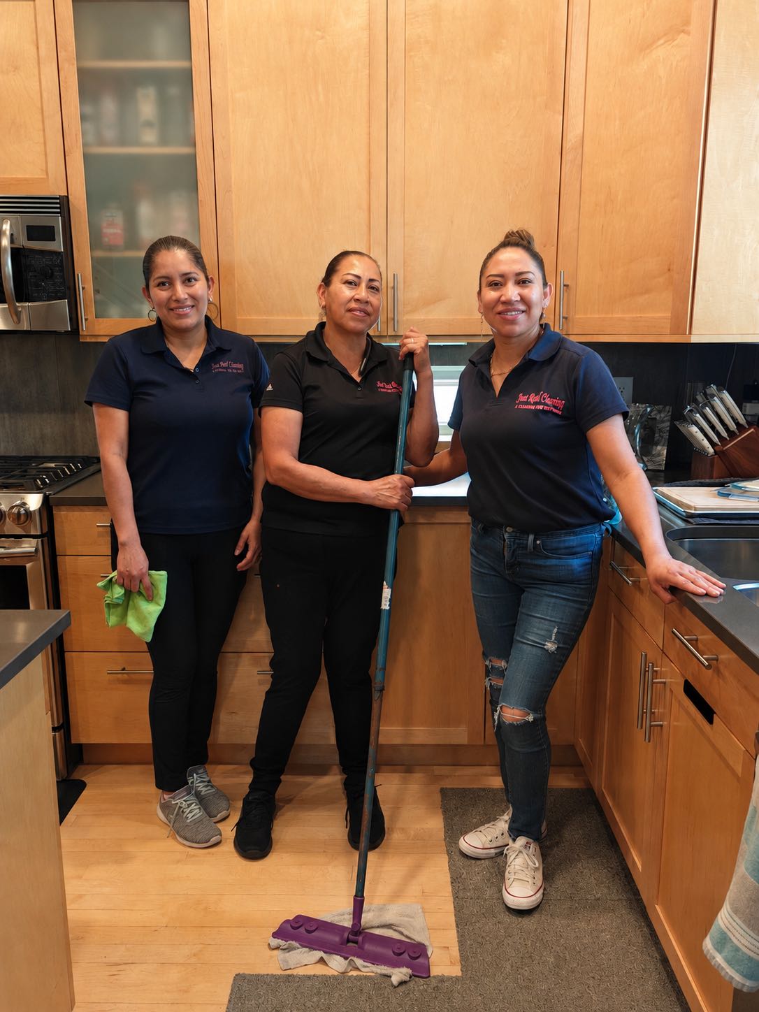 The Just Real Cleaning team smiling in a freshly cleaned kitchen.
